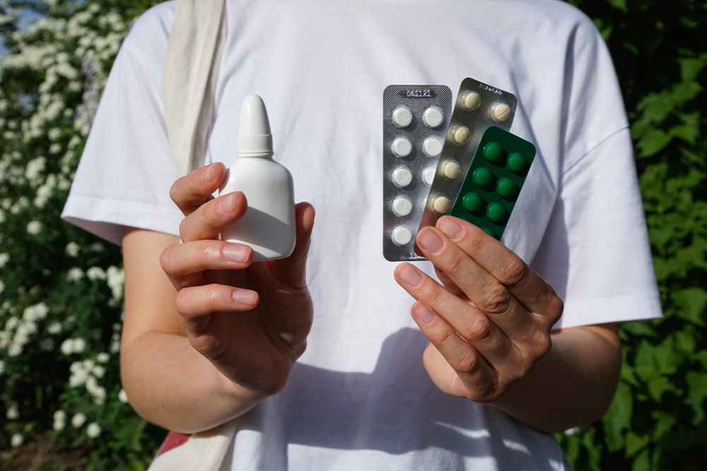 mains tenant des médicaments pour allergies en liquide et comprimés durant la saison de l'été sur la rive-sud de montréal
